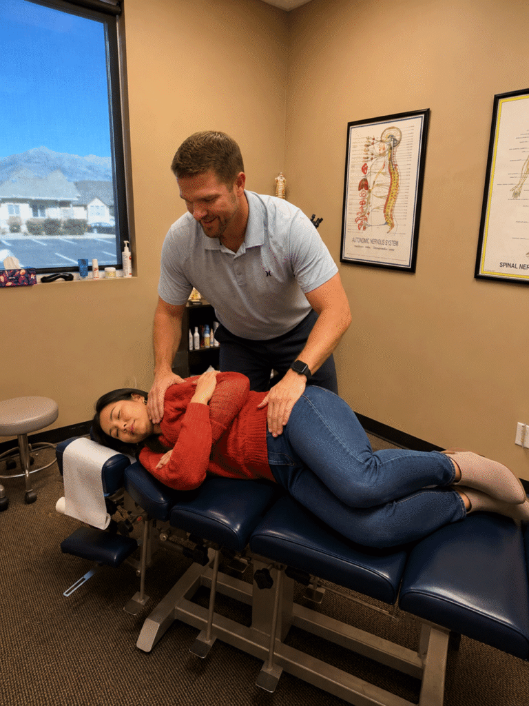 Dr. Aaron Walker performing a chiropractic adjustment on a woman at Dry Creek Chiropractic in Lehi, Utah